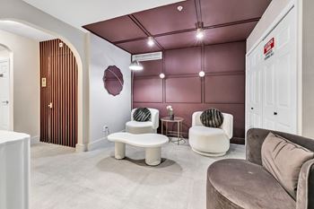 A living room with couches and chairs and a door